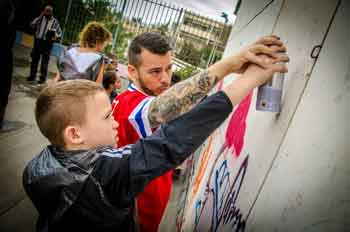 Craig Dershowitz, A4I founder, helps a child get creative with a can of spray paint.